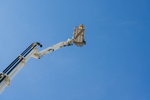 Firefighters in the fire truck crane rescue on building in the citycenter and blue sky background.Firefighters practice a plan to help victims in tall buildings.